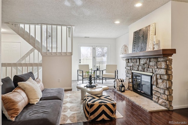 living room with hardwood / wood-style floors, a fireplace, and a textured ceiling