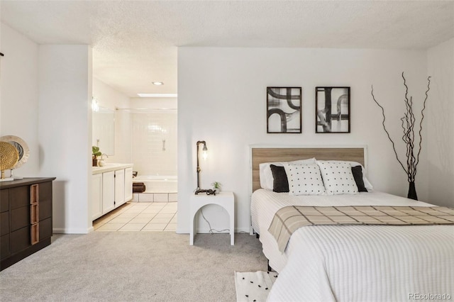 bedroom featuring connected bathroom, light colored carpet, and a textured ceiling