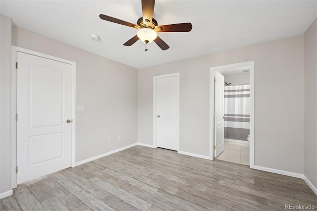 unfurnished bedroom with light wood-type flooring, a ceiling fan, baseboards, and connected bathroom