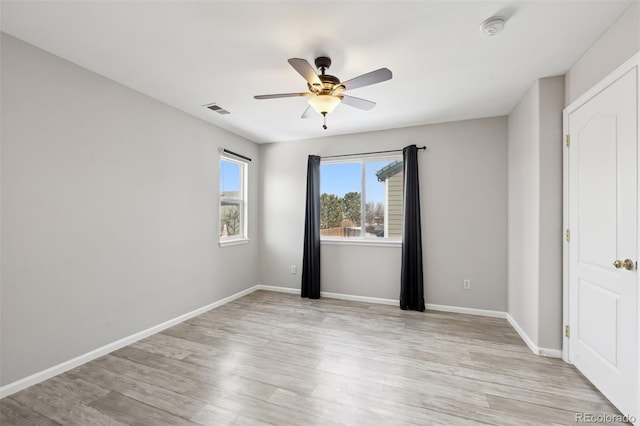 unfurnished room with light wood-type flooring, baseboards, visible vents, and ceiling fan