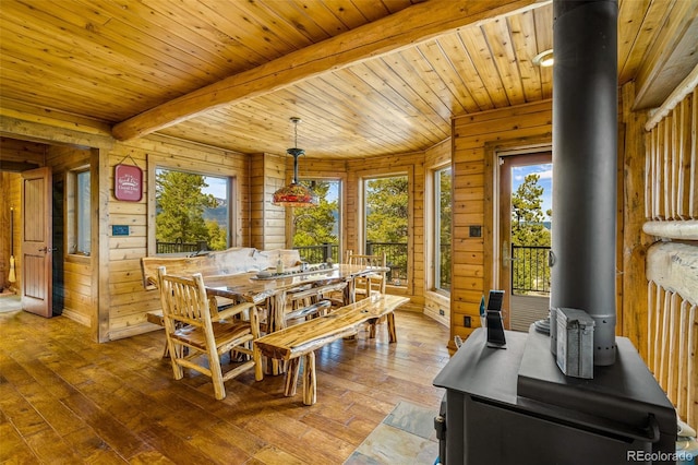 32806 Lakeside Dr, Buena Vista, CO 81211 - dining space featuring a wood stove, a wooden ceiling with exposed beams, wood walls, and hardwood / wood-style flooring