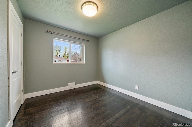 6026 Iris Way, Arvada, CO 80004 - unfurnished bedroom featuring a textured ceiling, baseboards, visible vents, and dark wood finished floors