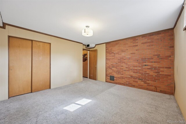 1055 N 18th St, Colorado Springs, CO 80904 - unfurnished bedroom with carpet floors, brick wall, and a closet