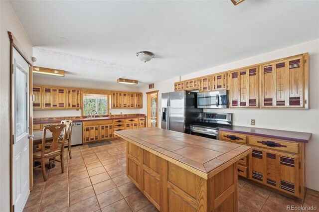 1055 N 18th St, Colorado Springs, CO 80904 - kitchen with tile patterned flooring, glass insert cabinets, tile counters, a sink, and appliances with stainless steel finishes