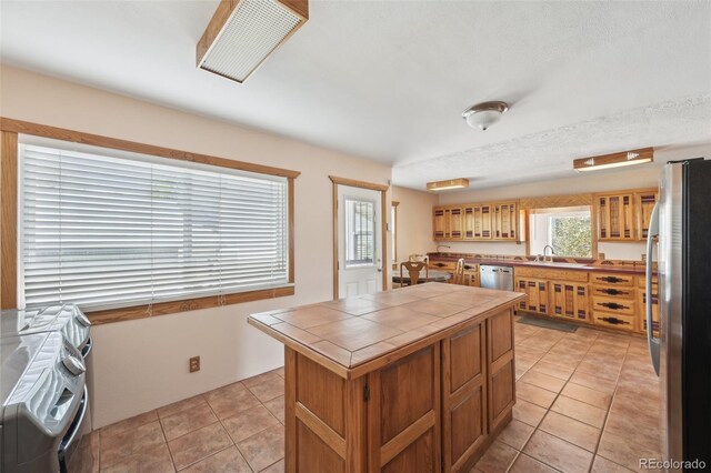 1055 N 18th St, Colorado Springs, CO 80904 - kitchen with tile counters, light tile patterned flooring, appliances with stainless steel finishes, and a sink