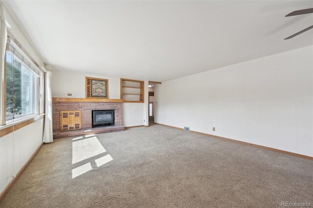 1055 N 18th St, Colorado Springs, CO 80904 - unfurnished living room with baseboards, a ceiling fan, a fireplace, and light carpet
