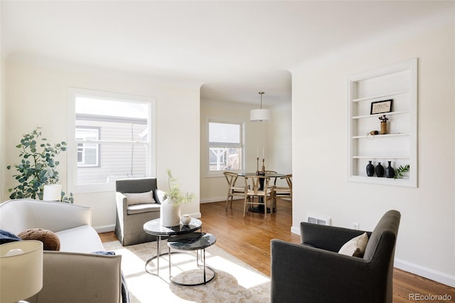 living room with hardwood / wood-style floors and built in features