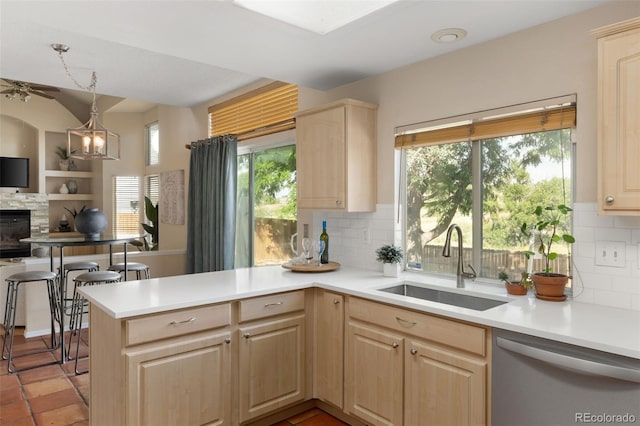 5649 W 109th Cir, Westminster, CO 80020 - kitchen with stainless steel dishwasher, light brown cabinetry, light countertops, tasteful backsplash, and lofted ceiling