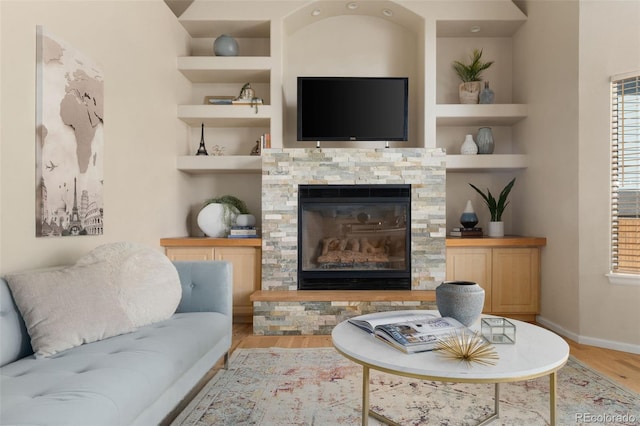 5649 W 109th Cir, Westminster, CO 80020 - living area with wood finished floors, built in features, a stone fireplace, and plenty of natural light