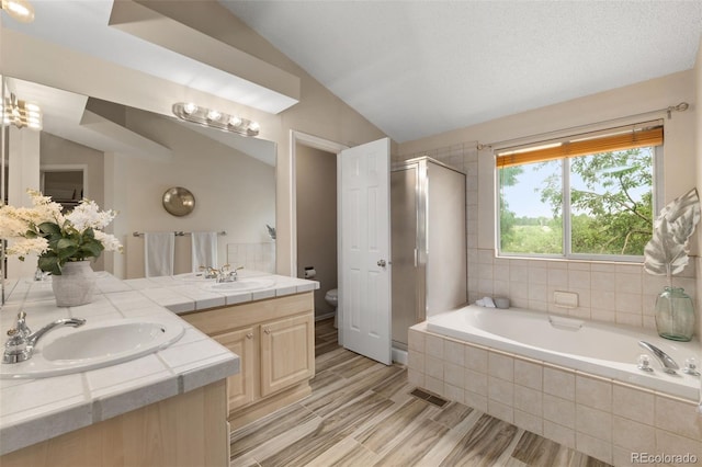 5649 W 109th Cir, Westminster, CO 80020 - full bathroom with a stall shower, double vanity, a garden tub, lofted ceiling, and wood finished floors