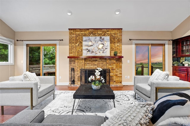 7883 S Espana Way, Centennial, CO 80016 - living area with healthy amount of natural light, a brick fireplace, wood finished floors, recessed lighting, and baseboards
