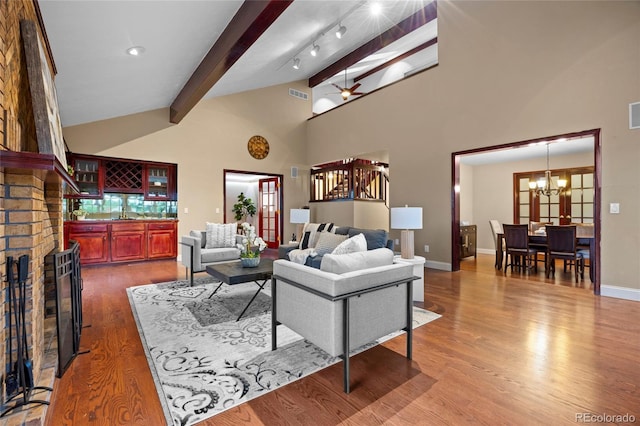7883 S Espana Way, Centennial, CO 80016 - living area with beamed ceiling, a chandelier, wood finished floors, high vaulted ceiling, and baseboards