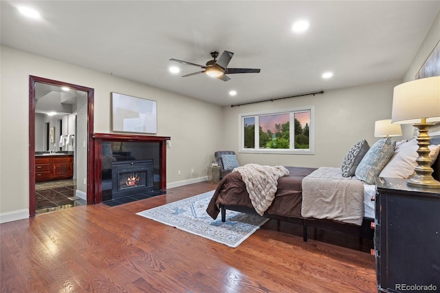 7883 S Espana Way, Centennial, CO 80016 - bedroom featuring wood finished floors, recessed lighting, baseboards, a fireplace with flush hearth, and a sink