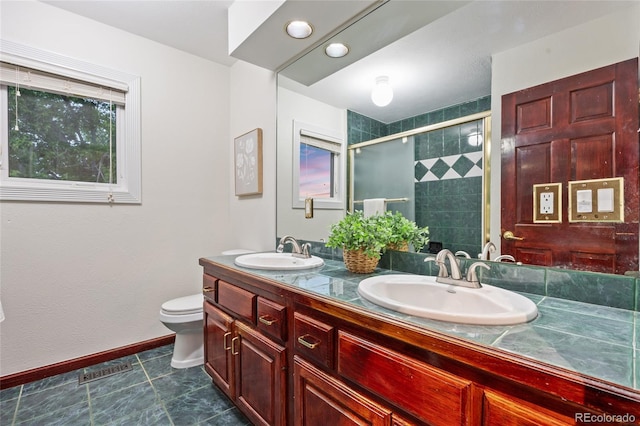 7883 S Espana Way, Centennial, CO 80016 - bathroom with double vanity, toilet, a stall shower, baseboards, and tile patterned flooring