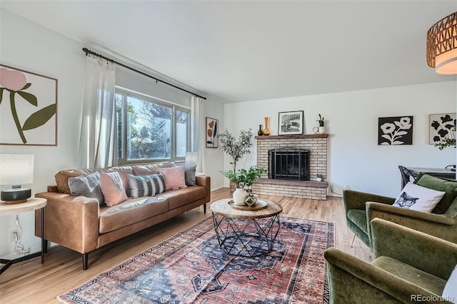 living room featuring hardwood / wood-style flooring and a brick fireplace