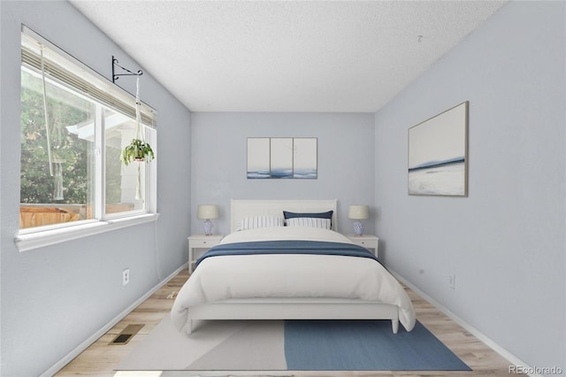 381 Mountain Cloud Cir, Highlands Ranch, CO 80126 - bedroom featuring light wood-style flooring, a textured ceiling, and baseboards