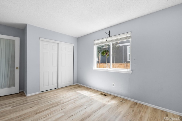 381 Mountain Cloud Cir, Highlands Ranch, CO 80126 - unfurnished bedroom with wood finished floors, a closet, baseboards, and a textured ceiling