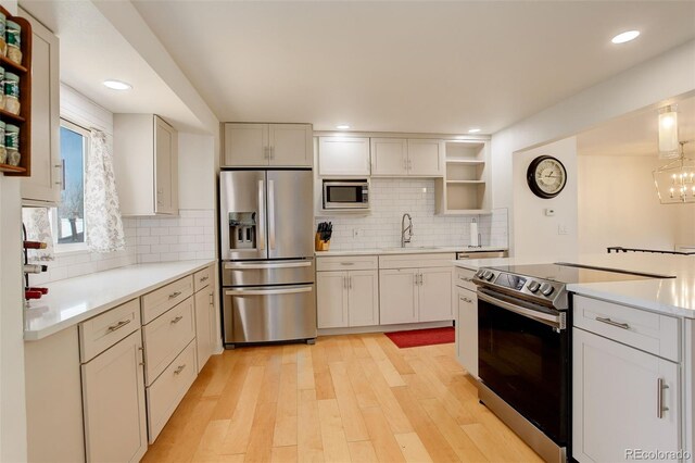 3785 S Benton Way, Denver, CO 80235 - kitchen featuring appliances with stainless steel finishes, open shelves, tasteful backsplash, light wood-style flooring, and light countertops