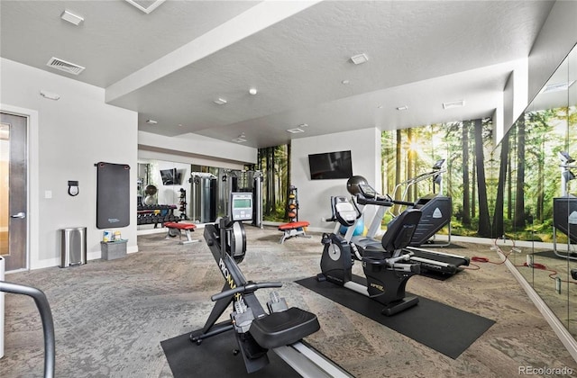 gym featuring carpet flooring, a textured ceiling, baseboards, and visible vents