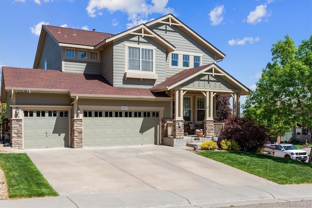 10448 Kicking Horse Dr, Littleton, CO 80125 - craftsman inspired home with a porch, roof with shingles, a garage, stone siding, and concrete driveway