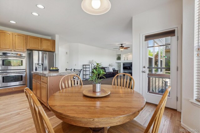 10448 Kicking Horse Dr, Littleton, CO 80125 - dining space with light wood-style floors, ceiling fan, a fireplace, and recessed lighting
