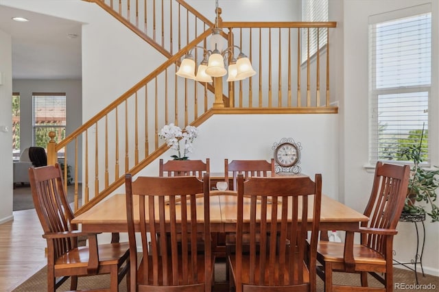 10448 Kicking Horse Dr, Littleton, CO 80125 - dining space featuring a chandelier, stairs, wood finished floors, baseboards, and recessed lighting