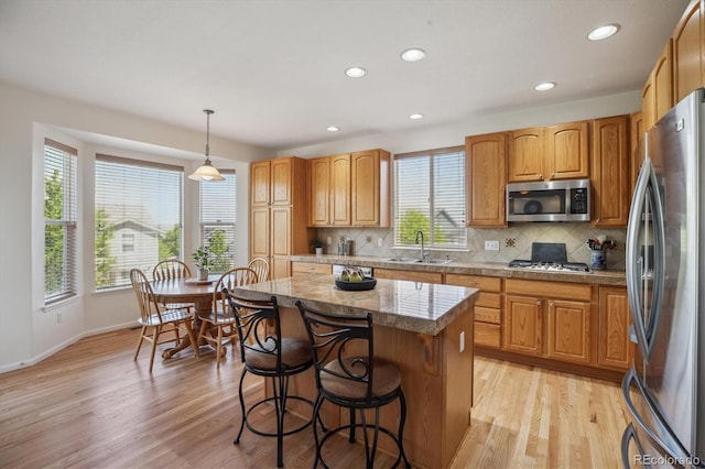10448 Kicking Horse Dr, Littleton, CO 80125 - kitchen with appliances with stainless steel finishes, tile countertops, a sink, a kitchen bar, and a center island