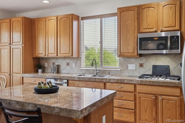 10448 Kicking Horse Dr, Littleton, CO 80125 - kitchen featuring appliances with stainless steel finishes, a sink, decorative backsplash, a kitchen island, and recessed lighting