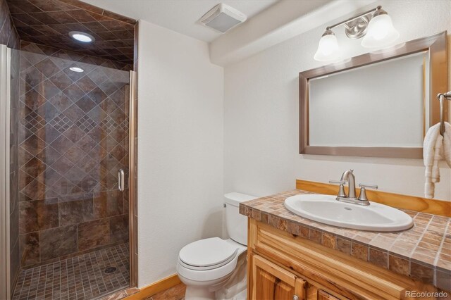 10448 Kicking Horse Dr, Littleton, CO 80125 - bathroom featuring toilet, vanity, a shower stall, and baseboards