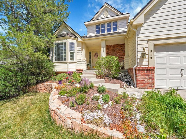 848 Huntington Pl, Highlands Ranch, CO 80126 - view of front facade with brick siding, an attached garage, and a front yard