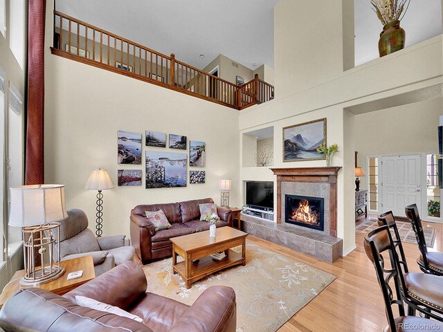 848 Huntington Pl, Highlands Ranch, CO 80126 - living area with a high ceiling, wood finished floors, a tile fireplace, and built in shelves
