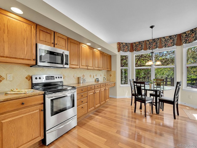 848 Huntington Pl, Highlands Ranch, CO 80126 - kitchen featuring appliances with stainless steel finishes, baseboards, light wood finished floors, and a chandelier