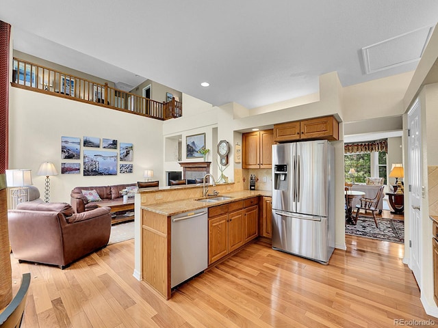 848 Huntington Pl, Highlands Ranch, CO 80126 - kitchen featuring stainless steel appliances, a sink, open floor plan, light wood-style floors, and a peninsula