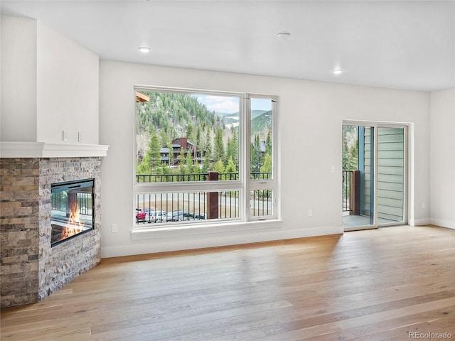 0125 W Keystone Rd Unit 209, Keystone, CO 80435 - unfurnished living room featuring wood finished floors, a glass covered fireplace, baseboards, and recessed lighting