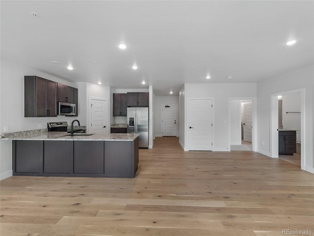 0125 W Keystone Rd Unit 209, Keystone, CO 80435 - kitchen with appliances with stainless steel finishes, a sink, a peninsula, light wood-style flooring, and baseboards