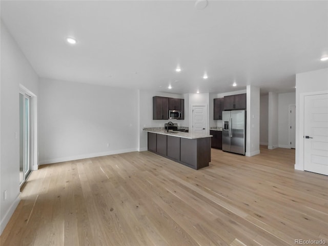 0125 W Keystone Rd Unit 209, Keystone, CO 80435 - kitchen featuring appliances with stainless steel finishes, dark brown cabinetry, light countertops, light wood finished floors, and open floor plan