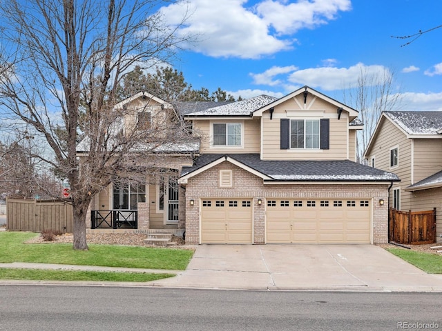 view of front of property with a garage, brick siding, driveway, and fence