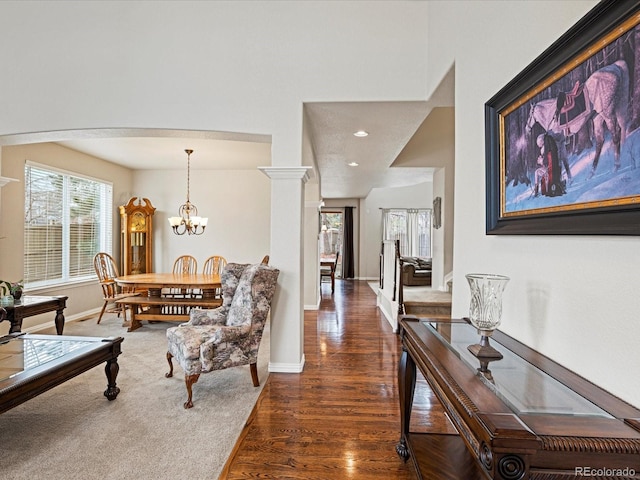hall featuring baseboards, a chandelier, recessed lighting, arched walkways, and wood finished floors