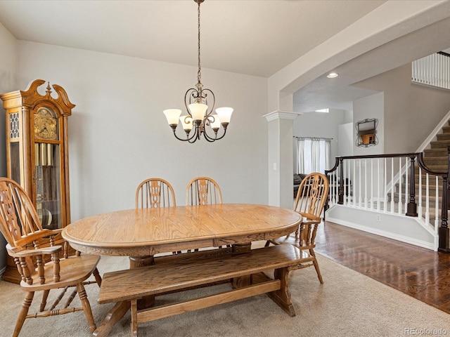 dining space featuring baseboards, a chandelier, stairs, arched walkways, and wood finished floors