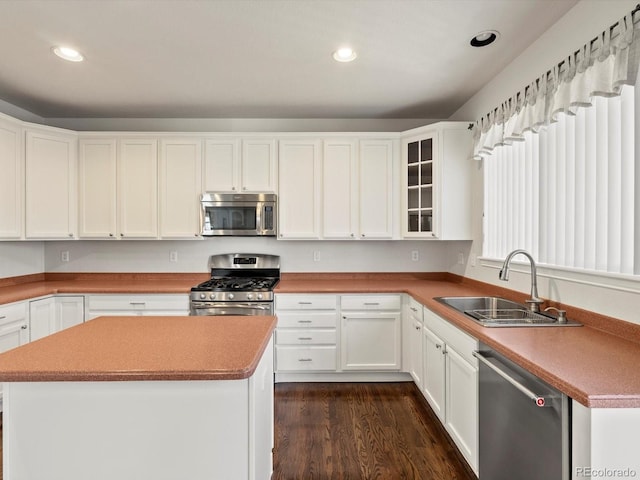 kitchen featuring recessed lighting, white cabinets, dark wood finished floors, stainless steel appliances, and a sink