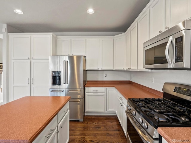 kitchen with white cabinets, appliances with stainless steel finishes, and dark wood-style floors