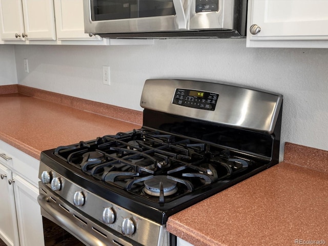 interior details with white cabinetry and appliances with stainless steel finishes