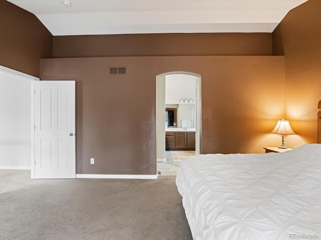 carpeted bedroom featuring arched walkways, visible vents, baseboards, and lofted ceiling