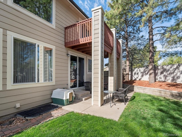 back of property with a yard, fence, a patio, and a balcony