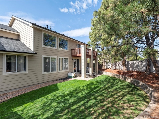 back of property with a balcony, a lawn, fence, a patio, and a shingled roof