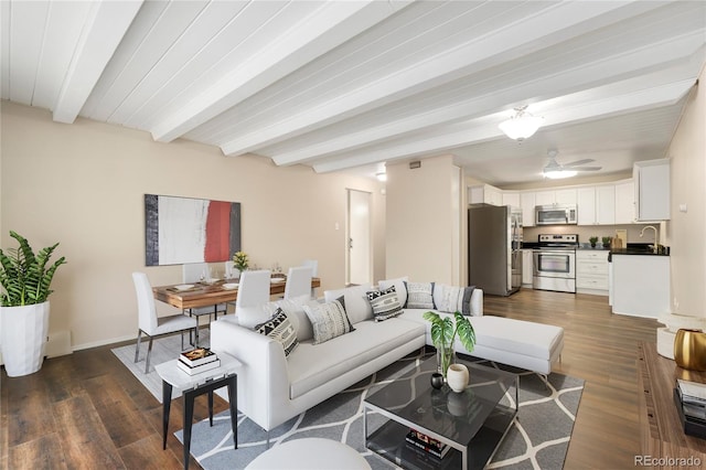 living room with ceiling fan, dark wood-type flooring, and beam ceiling