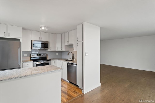 kitchen with decorative backsplash, stainless steel appliances, sink, white cabinets, and dark hardwood / wood-style floors