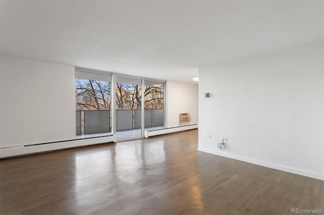 spare room with dark hardwood / wood-style floors and baseboard heating