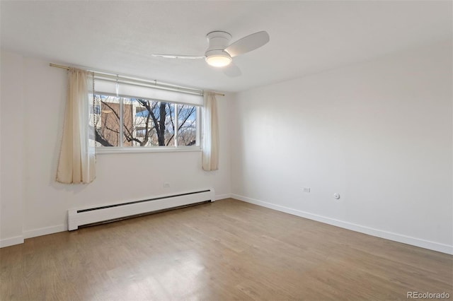 empty room featuring ceiling fan, light hardwood / wood-style floors, and baseboard heating