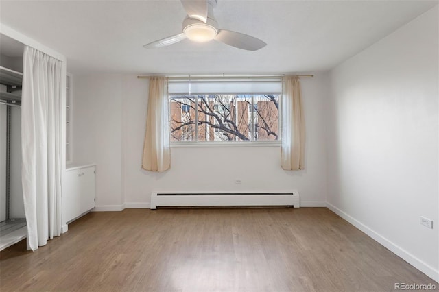 unfurnished bedroom with ceiling fan, baseboard heating, and light hardwood / wood-style flooring